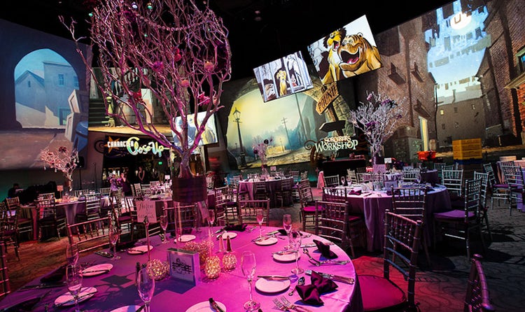 Round tables with many place settings arranged in a dark room