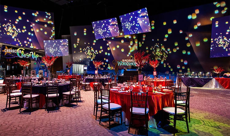 An event room with projection panels depicting artwork of the floating lanterns from Tangled