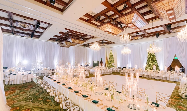 A ballroom with high ceilings and curtains surrounding a dance floor in the center of the room