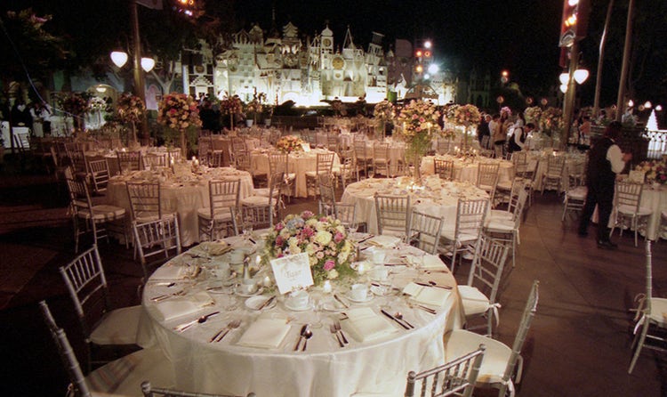 Several round tables with place settings arranged near 'it's a Small World'