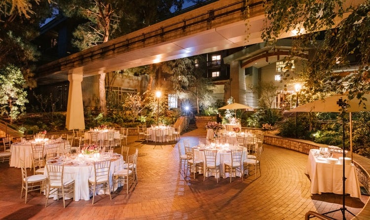 Tables and chairs in a courtyard beneath monorail tracks at Disney’s Grand Californian Hotel and Spa