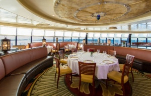 Multiple booths and tables set for service in the circular dining room of Palo restaurant