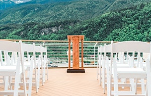 Folding chairs on the deck of ship overlooking a hillside