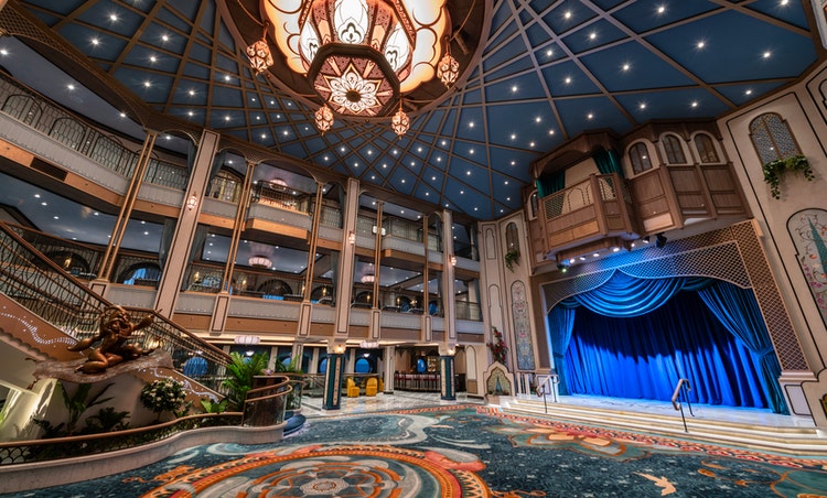 The main stage in the Grand Hall across from a statue of Aladdin and Jasmine aboard the Disney Treasure