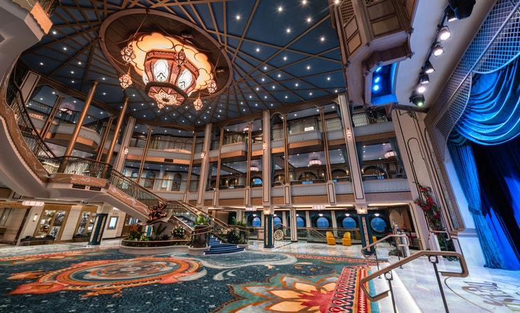 The Grand Hall glows with warm lighting on the Disney Treasure