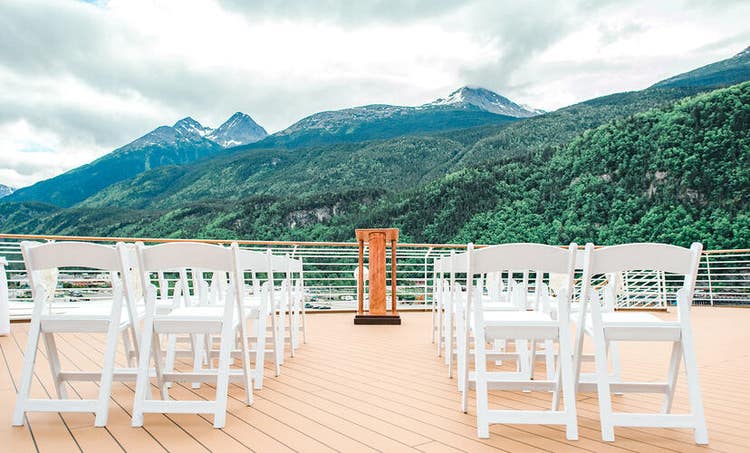 Several rows of chairs facing a podium on an outdoor patio area