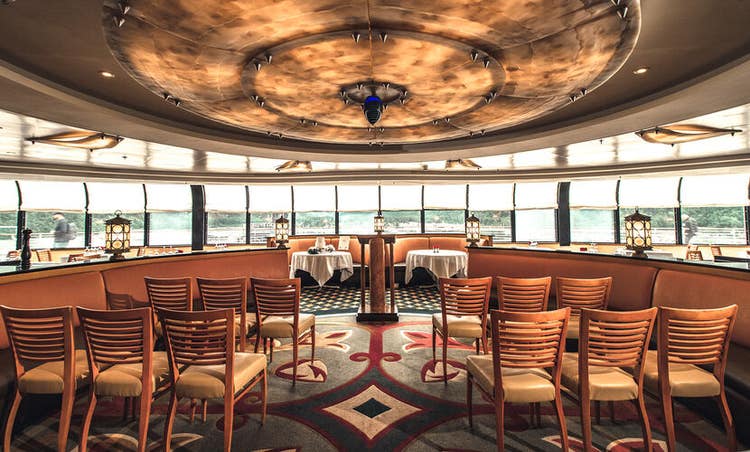 Rows of chairs set up to face windows that reveal a view of the ocean