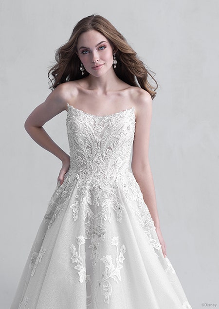 A woman stares down at the Aurora wedding gown from the 2021 Disney Fairy Tale Weddings Platinum Collection that she is wearing