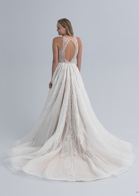 A bride in a wedding dress with a cutout in the back of the dress and a full skirt
