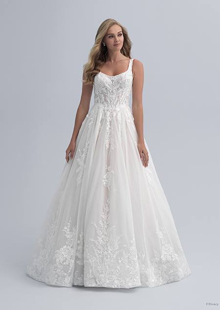 A woman wearing a wedding dress with a square neckline with a flowered bodice and flowers extending through the skirt