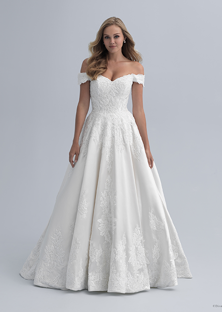 A bride in an off the shoulder wedding dress with a fitted waist and semi full skirt