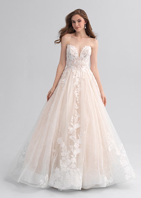 A woman wearing a lacy wedding dress with a full skirt and detachable sleeves