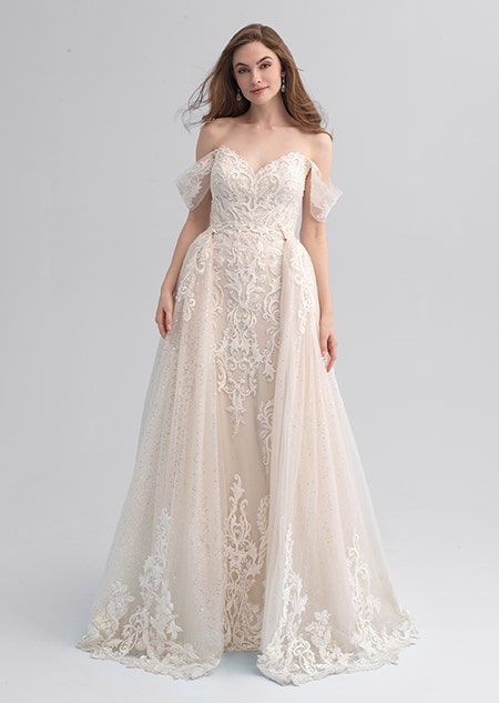 A woman wearing a lacy wedding dress with loose sleeves