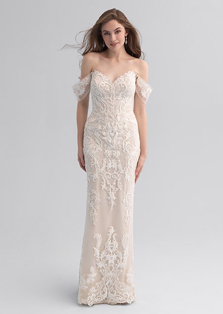 A woman wearing a form fitting wedding dress covered in a lace patter