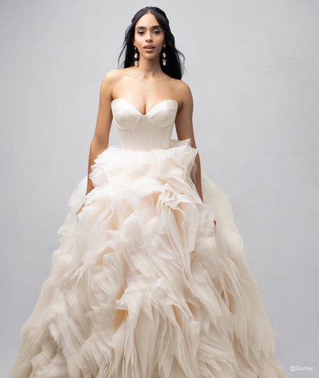 The front of a bride wearing a Belle inspired ball gown with a sweetheart neckline and a ruffled skirt