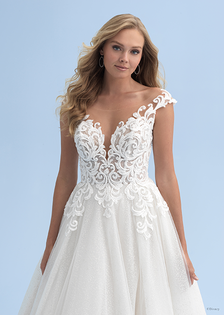 A bride with long hair wearing a wedding dress with an illusion neckline