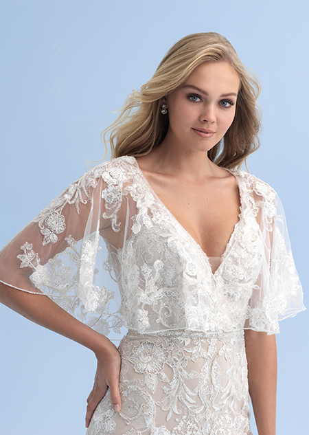 A bride wearing a see thru shall with crystal flowers over her wedding dress