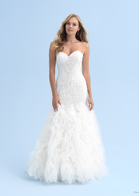 A woman in a form fitting wedding dress with a ruffled skirt