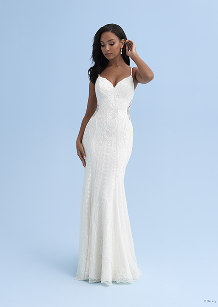 A woman in a form fitting wedding dress with skinny straps and cutouts on the sides