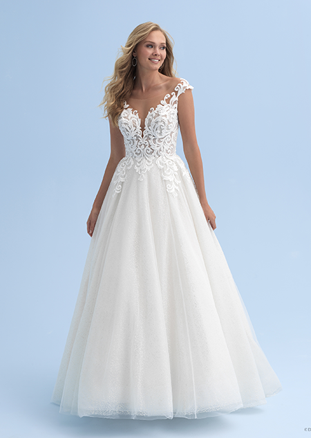A bride wears a wedding dress with a deep neckline and straps across her shoulders