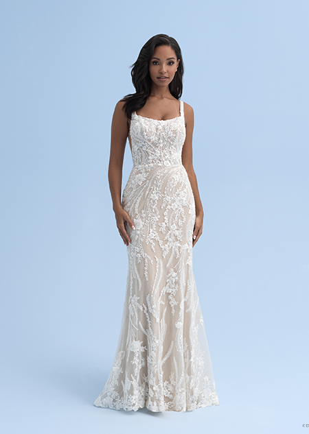 A bride in a form fitting wedding dress with a square neckline decorated with crystal flowers