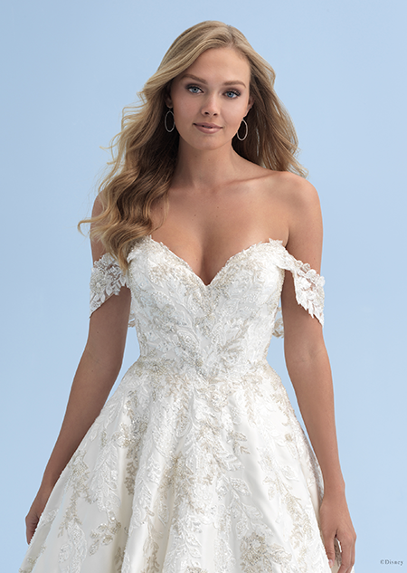 A close up of a woman in an off the shoulder wedding dress with crystals adorning the bodice and skirt