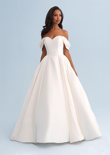 A woman wearing a off the shoulder wedding dress with a full skirt