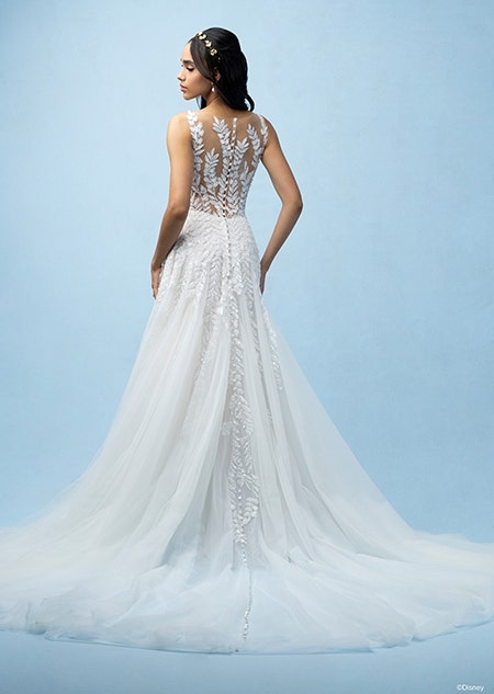 The back of a bride wearing a Pocahontas inspired A line gown featuring a train and a bodice and straps with a beaded leaf design