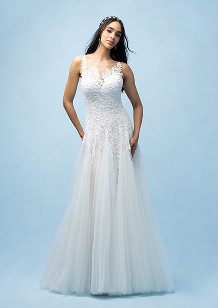 The front of a bride wearing a Pocahontas inspired A line gown featuring a sweetheart neckline and a bodice and straps with a beaded leaf design