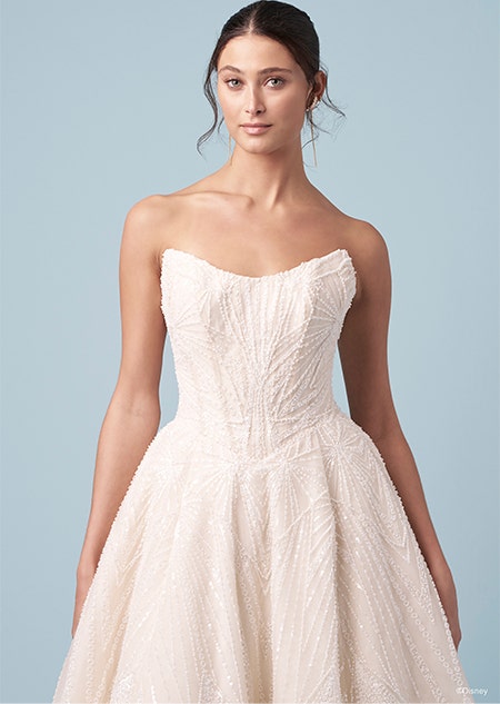 A bride wearing a strapless Tiana inspired A line gown featuring a scoop neckline