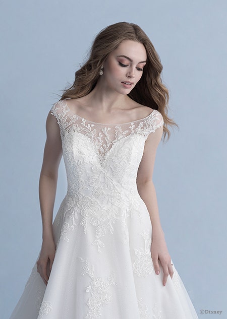 A woman glances down at the Snow White wedding gown from the 2020 Disney Fairy Tale Weddings Collection that she is wearing