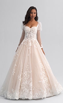 A woman wearing a long sleeved and lacy wedding gown with puffy sleeves