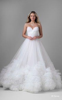 A bride wearing a Rapunzel inspired ball gown featuring a sweetheart neckline and ruffles around the hem