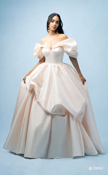 A bride wearing a Belle inspired ball gown featuring an off the shoulder neckline