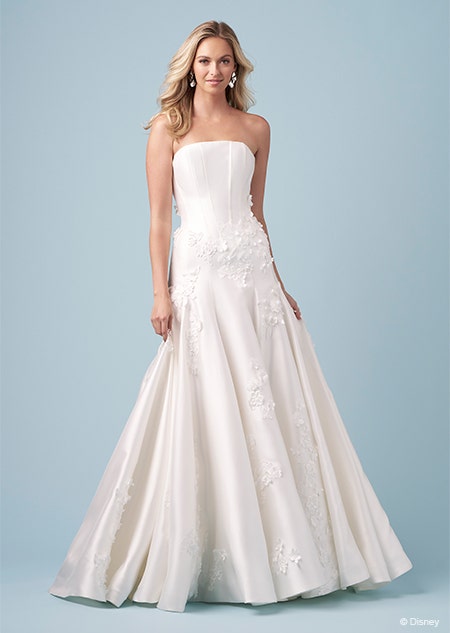 A bride wearing a strapless Aurora inspired A line gown with embroidered flowers