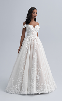 A woman wearing a wedding dress with an off the shoulder neckline and flowers adorning the bodice and extending down the skirt