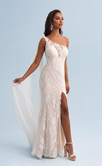A woman wearing a form fitting wedding dress with a lace leaf pattern and asymmetrical sleeves