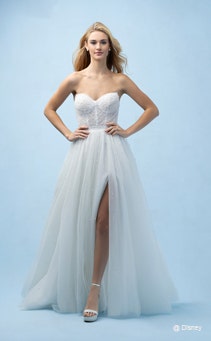 A bride wearing an Ariel inspired A line gown featuring a sweetheart neckline, lightly beaded fabric and a high slit in the skirt