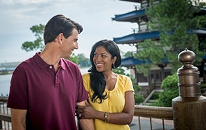 A smiling couple holding hands while walking through the China Pavilion at World Showcase in Epcot