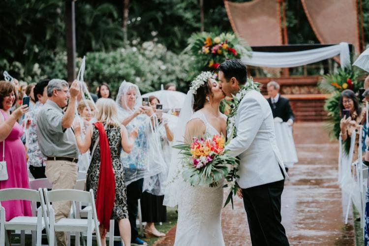 bride and groom, couple, wedding ceremony, ceremony, kiss, candid, exit, couple exit, tropical floral, colorful floral, palm fronds, flower crown, lei, halawai lawn, aulani, halawai