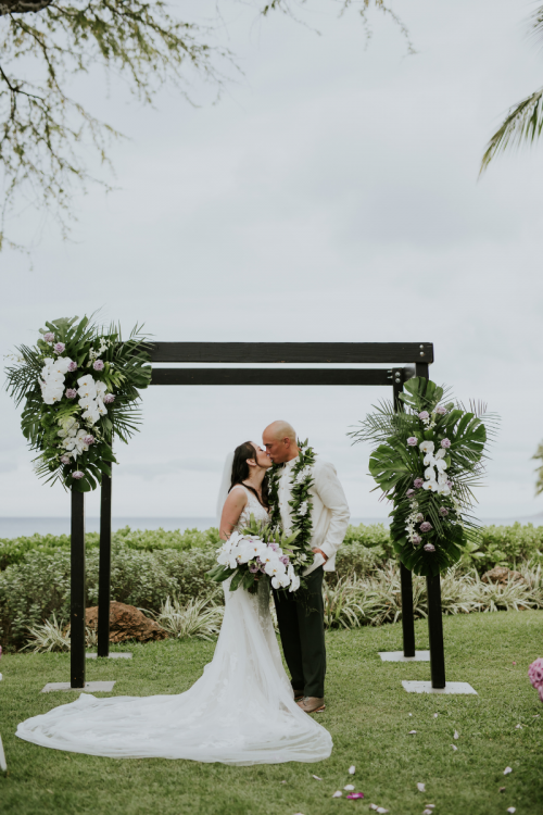 bride and groom, kiss, bride and groom kiss, altar, altar decor, altar floral, lei, hawaii, aulani, aulani wedding, bridal bouquet