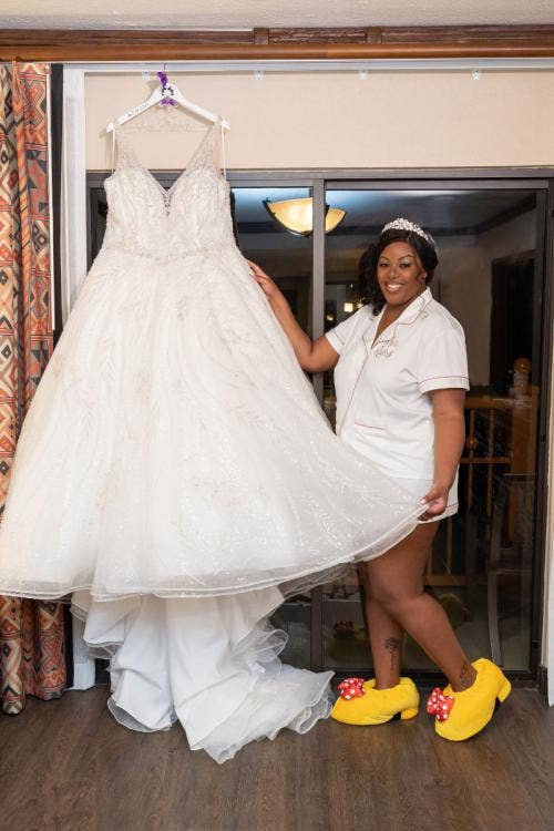bride, getting ready, bridal portrait, wedding dress, slippers, minnie mouse slippers, disney's animal kingdom lodge, animal kingdom lodge, hotel room, wedding dress