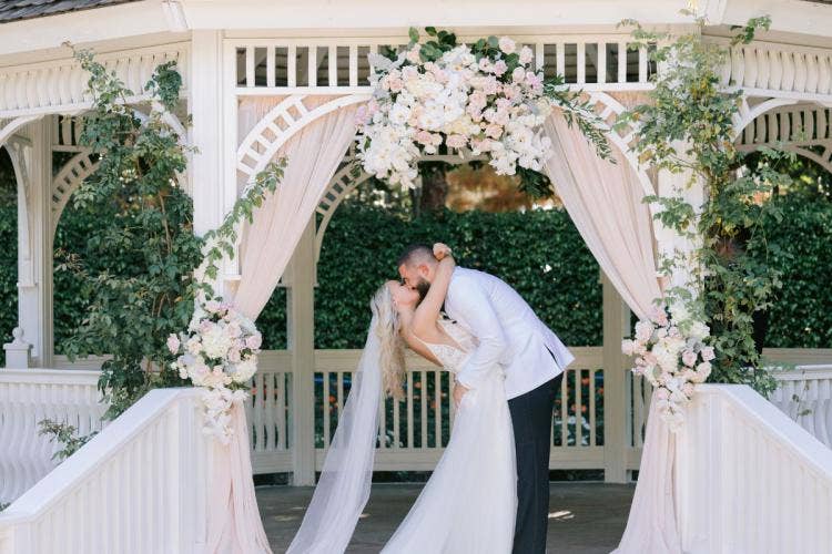 bride and groom, couple, first kiss, kiss, wedding ceremony, ceremony, rose court, rose court garden, Disneyland, Disneyland Hotel