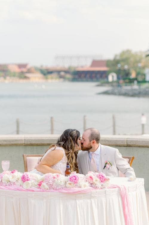 bride and groom, couple, kiss, sweetheart table, wedding reception, reception, summerhouse patio, grand floridian