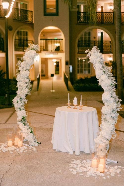 wedding ceremony, ceremony, ceremony decor, decorated ceremony, altar arch, floral arch, altar floral, white floral, string lights, aisle floral, aisle decor, aisle candles, candles, Coronado, Coronado springs, casitas, casitas courtyard, altar area