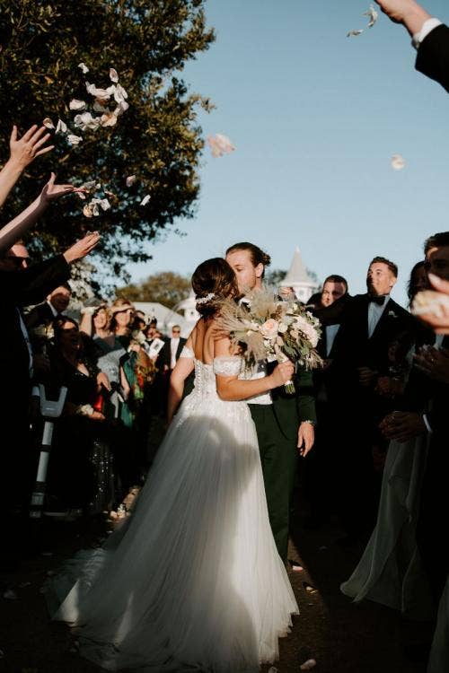 bride and groom, couple, exit, kiss, Disney's wedding pavilion, wedding pavilion, personal floral, floral, bridal bouquet, boho floral