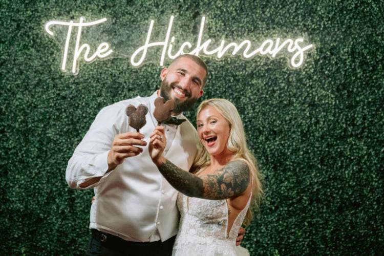 bride and groom, couple, portrait, wedding reception, reception, greenery wall, decor, reception decor, reception floral, mickey ice cream bar, mickey bar, dessert