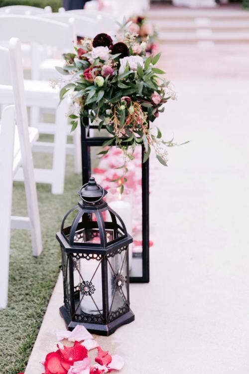 wedding ceremony, ceremony, ceremony decor, ceremony floral, aisle decor, aisle floral, aisle lanterns, black lanters, pink petal toss, petal toss, moody aesthetic, moody floral, halloween, halloween theme