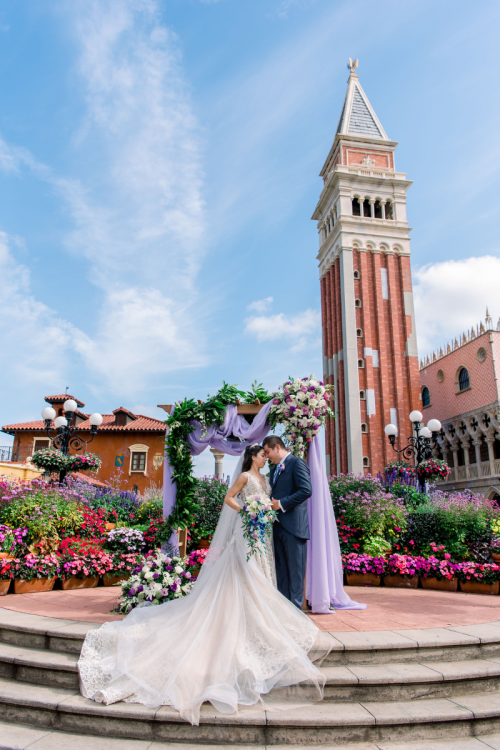 bride and groom, couple, portrait, wedding ceremony, ceremony, altar area, decorated atlar, altar, floral, altar floral, purple, purple floral, purple drape, italy, italy pavilion, epcot, italy plaza