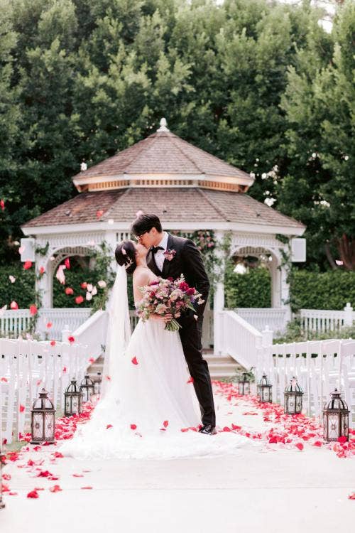 bride and groom, couple, portrait, couple portrait, wedding ceremony, ceremony, rose court garden, rose court, disneyland hotel, disneyland, halloween, halloween theme, moody floral, moody aesthetic, black lanterns, aisle floral